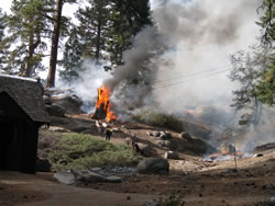 Fire crews pre-treat wooden structures with water and foam as additional structure protection on the Lodge prescribed fire