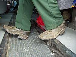 view of firefighter's legs and boots on crew bus