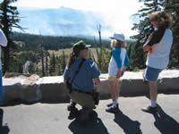 Picture of a Crater Lake National Park information officer talking with park visitors.