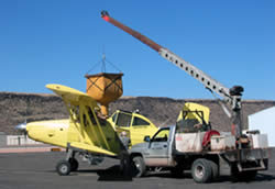 Picture of seed being loaded into a small airplane.