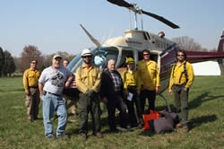 Helitack crew posed in front of a helicopter.