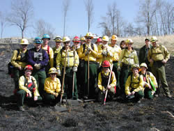The burn crew poses in the recently burned, but now cold, field.