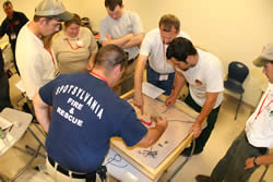 Students gather around the sand table.