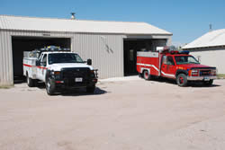 The NPS Type 6 engine and the Town of Fort Laramie’s brush truck are shown in front of Fort Laramie National Historic Site's old maintenance shop.
