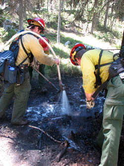 Firefighters using foam to extinquish hot spots on the Trail Fire.
