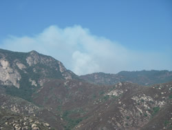 View of smoke rising over the mountains.