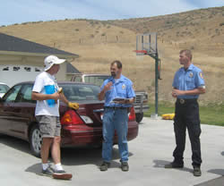 Payette Rural firefighter Justus Barton and resident Greg Frates review data about Frates' home.