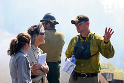An information officer explains the fire to park staff.