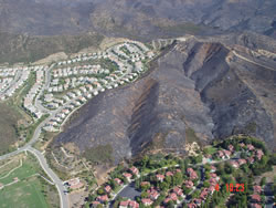 Aerial photograph of a community and a burned area at its edges.