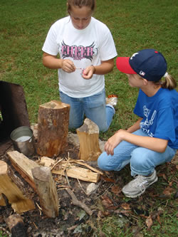 Campers Cassie Gray and Reagan Taylor compete to build a fire.