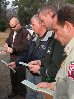 Members of the Manns Harbor VFD, Stumpy Point VFD, U.S. Fish and Wildlife Service and North Carolina Division of Forest Resources discuss tactics for protecting homes from a large wildfire.