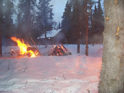 Burning piles near cabin.