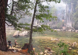 Fishermen recreate along the Kings River across from the Sheep Fire.