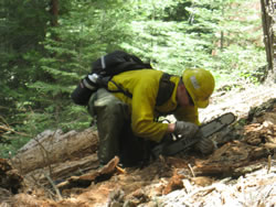 A firefighter checking and sharpening his chainsaw.