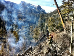 A firefighter hikes in to the confluence of Spruce and Forest Canyons.